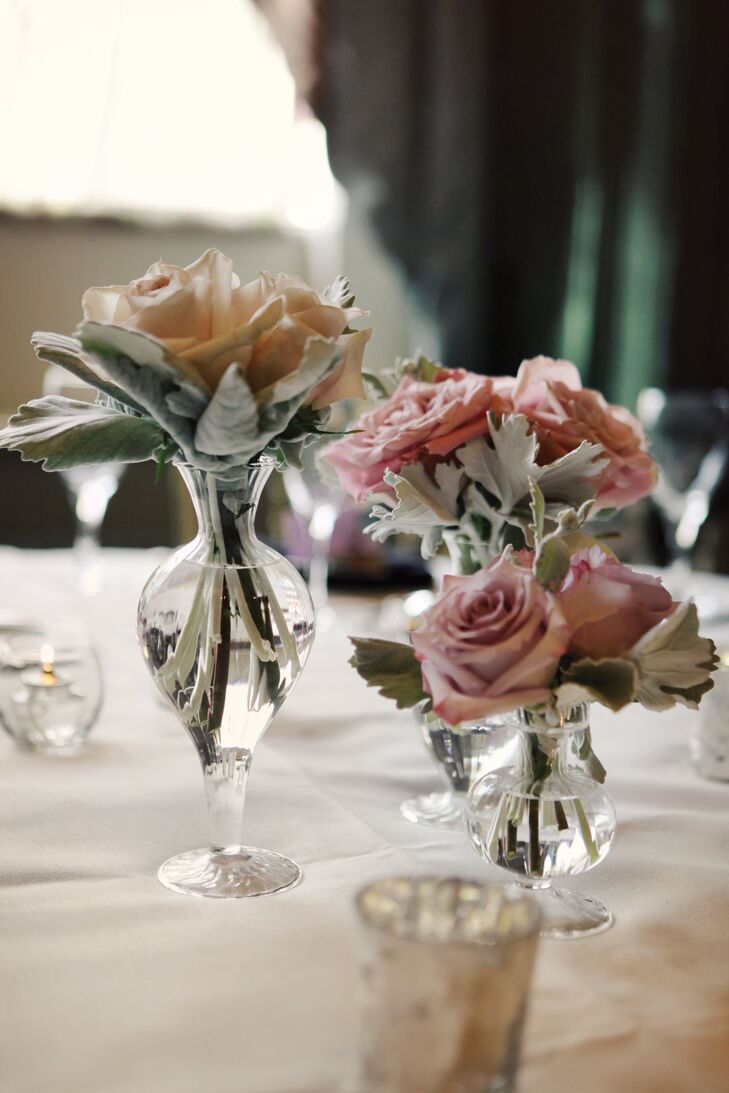 Small centerpieces echoed the design of the bouquets, with hydrangeas, roses and dusty miller in glass vases.