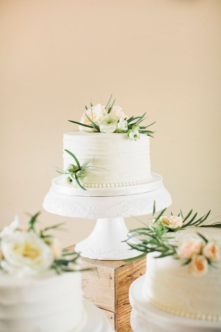Nicole and Tom had three single-tier wedding cakes by One Belle Bakery. Inside, they were amaretto cake with amaretto custard, red velvet with cream cheese and chocolate with chocolate custard. Each cake featured a different texture with off-white buttercream frosting and fresh flowers on top.