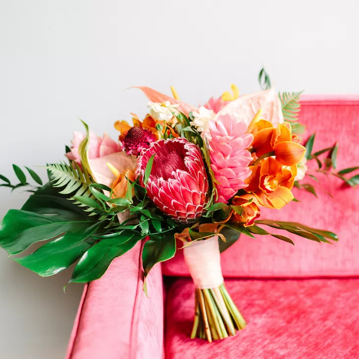 Tropical protea wedding bouquet with monstera leaves