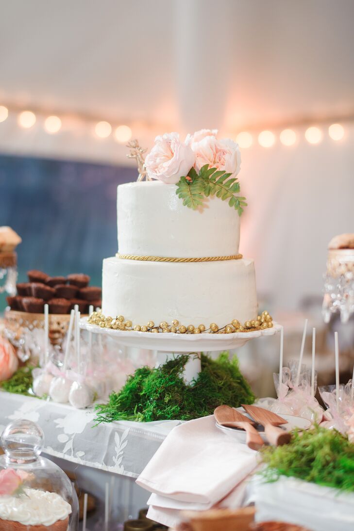 Erica and Cole chose a simple two-tier buttercream frosted vanilla cake by show Me Love Pops for the reception. It was topped with two gold deer and blush garden roses. Gold berries or a gold rope design was placed at the base of either tier. The cake was surrounded by a grand assortment of desserts and placed atop a white vintage piano.