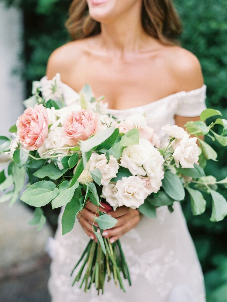 bride holding hand-tied wedding bouquet with pink garden roses and greenery