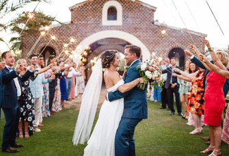 Bride and groom smiling during wedding reception entrance.