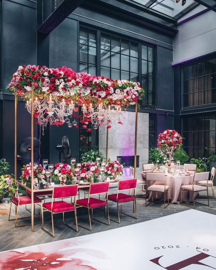 Glam Reception Table With Chandeliers and Flowers Hanging From Above