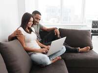 Couple using laptop together at home