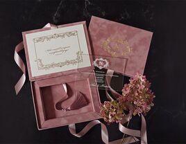 Mauve velvet box with mirror cover and gold foil imprint, event details in elegant type