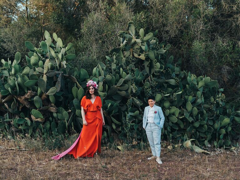 Couple poses in front of a large cactus. 
