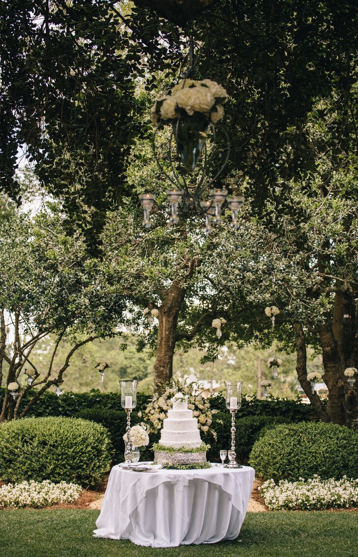 The couple had a five-tier french vanilla cake with buttercream frosting sitting on a silver cake stand with greenery and fresh gardenias on top.