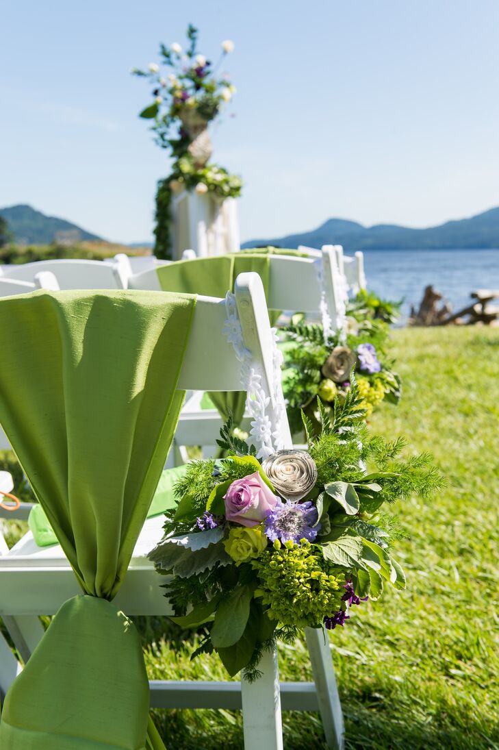 Arrangements of rose, fern, paper flowers and lavender hung from the aisle seats at the outdoor ceremony.