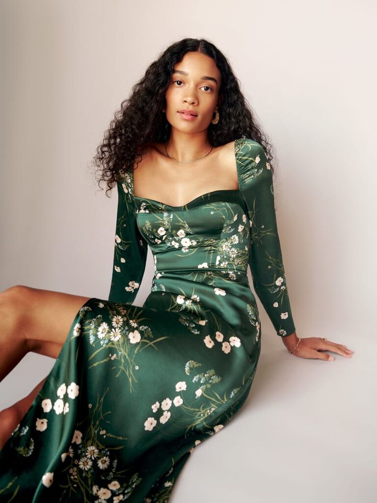 Model wearing a long sleeve green dress with a sweetheart neckline and floral details