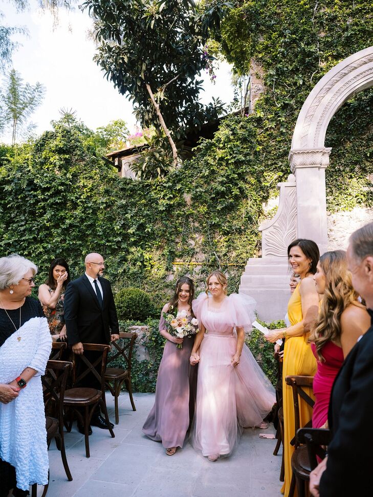 Bride in Blush Gown Walking With Daughter in Lavender Down the Aisle in Historic Venue