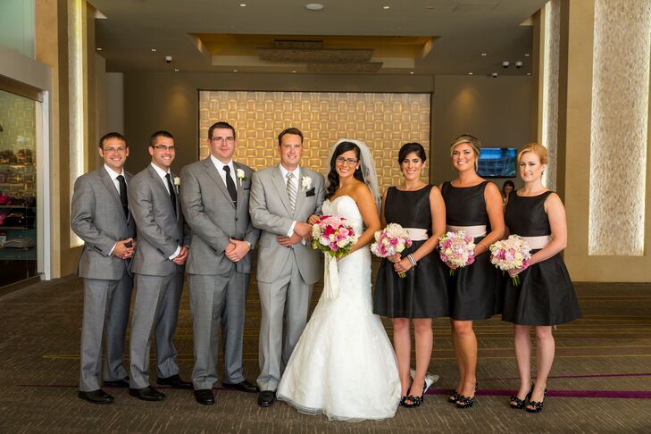Holly's bridesmaids wore short black A-line dresses with pink sashes and bows on the back along with black and white polka dot pumps.