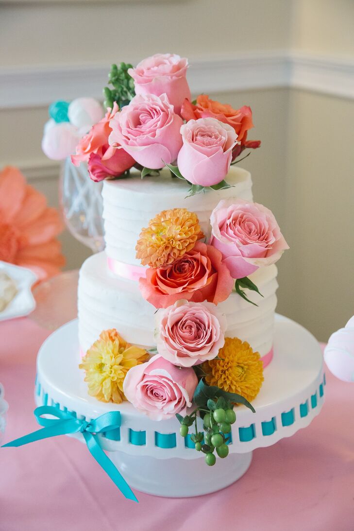 The simple two tier cake was decorated with fresh bunches of bright pink and coral roses and yellow dahlias.