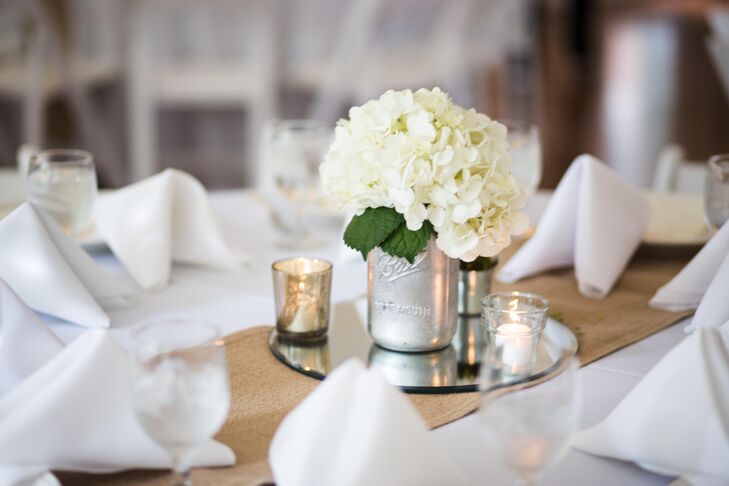 Mandy designed all the reception dining tables' decor using elegant and rustic elements. She chose white hydrangeas, surrounding candlelight and burlap table runners.