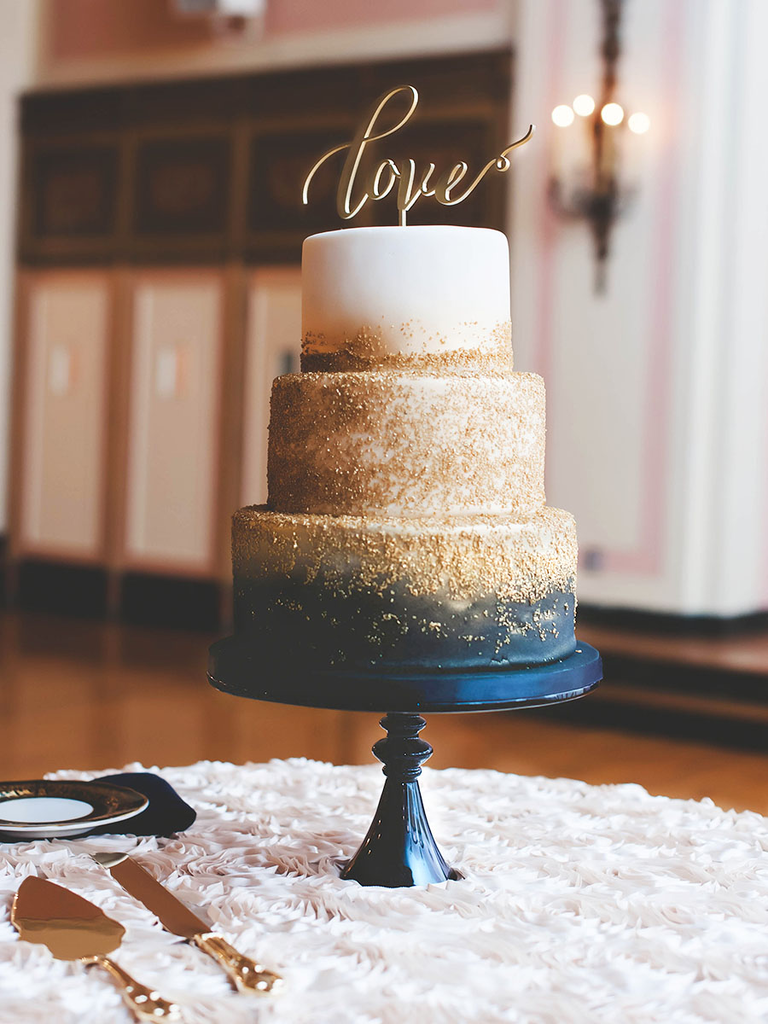 Navy and gold wedding cake with calligraphed cake topper
