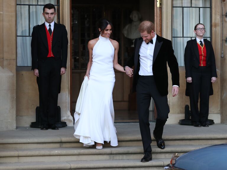 Meghan Markle wears a chic white dress with a high neckline. 