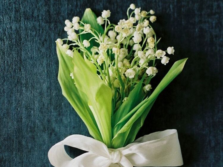 A petite lily of the valley bouquet tied with a white ribbon