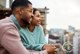 couple holding hands and looking out over city