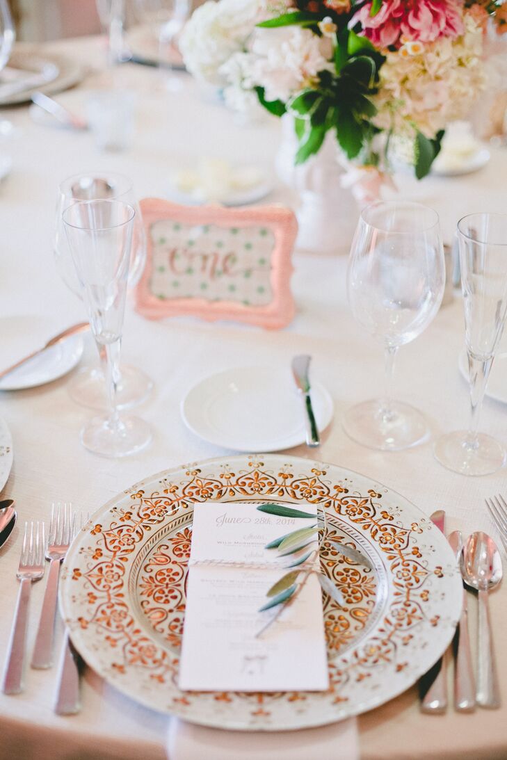 Decorated with an intricate gold design, the dinnerware tied into the evening's rose gold theme, will taking the tablescapes to glam new heights. Each plate was adorned with olive leaves for a touch of rustic flair.
