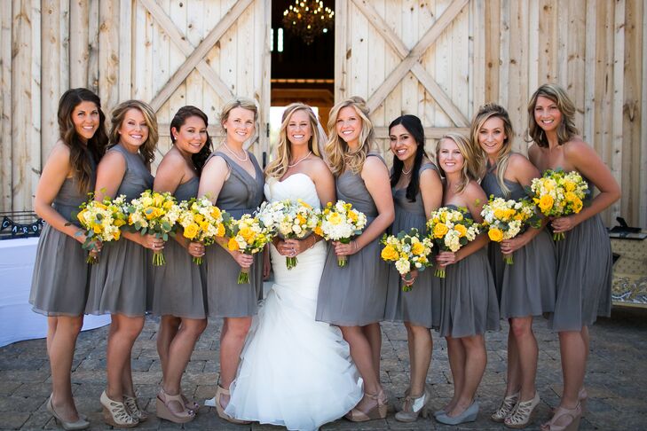 Lauren stood in the middle of her bridesmaids dressed in charcoal gray knee-length dresses, with the on-site barn as a backdrop. Although the women wore the same-colored dress, each had a completely different style.