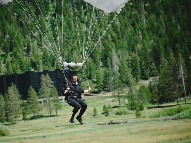 Groom parachuting into wedding reception.