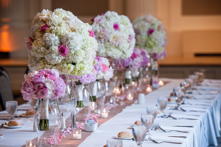 The altar decorations and bridesmaid bouquets were repurposed at the reception as head table decor. The tall arrangements of hydrangeas and roses fit in perfectly with the pink and white color scheme.