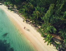 A couple walks along the inviting sands of a beach in the Dominican Republic.