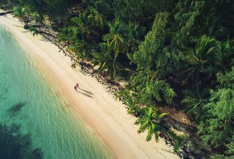 A couple walks along the inviting sands of a beach in the Dominican Republic.