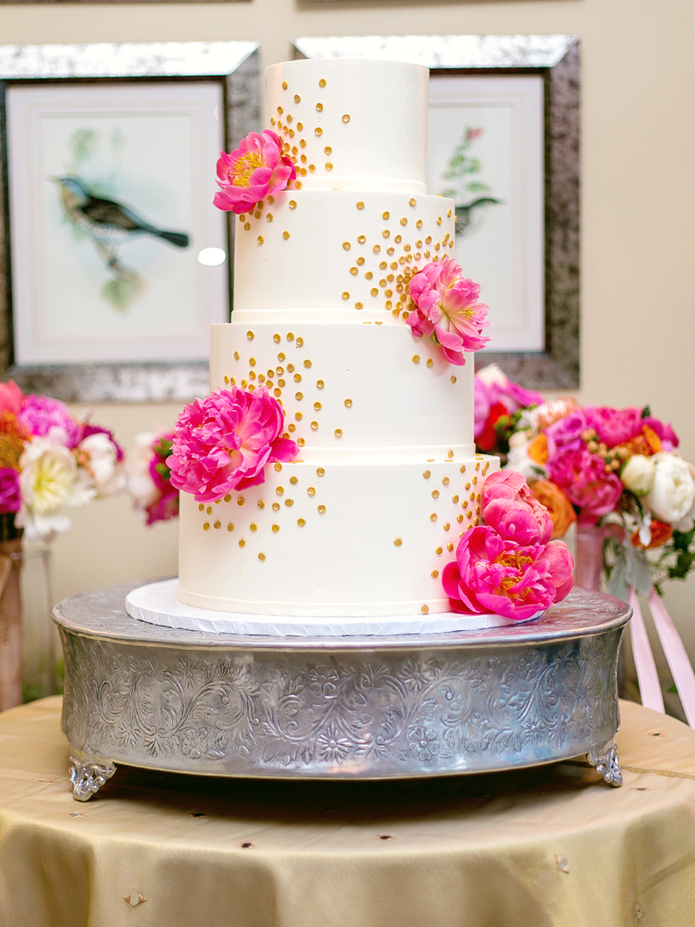 White wedding cake with pink peonies and gold polka dots