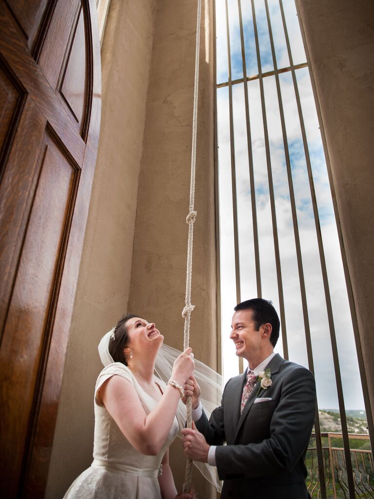 Bride and groom pulling a church bell rope.