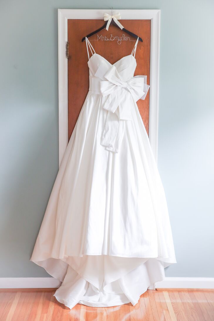 A cathedral-length veil was a must for Lauren, who donned a classic A-line style complete with a large bow detail on the bodice. After showing her bridal consultant a photo of her dream gown, Lauren was shown the exact replica of the dress without the bow. "She assured me that the seamstress could create the bow that it was missing," Lauren says of the all-white design.