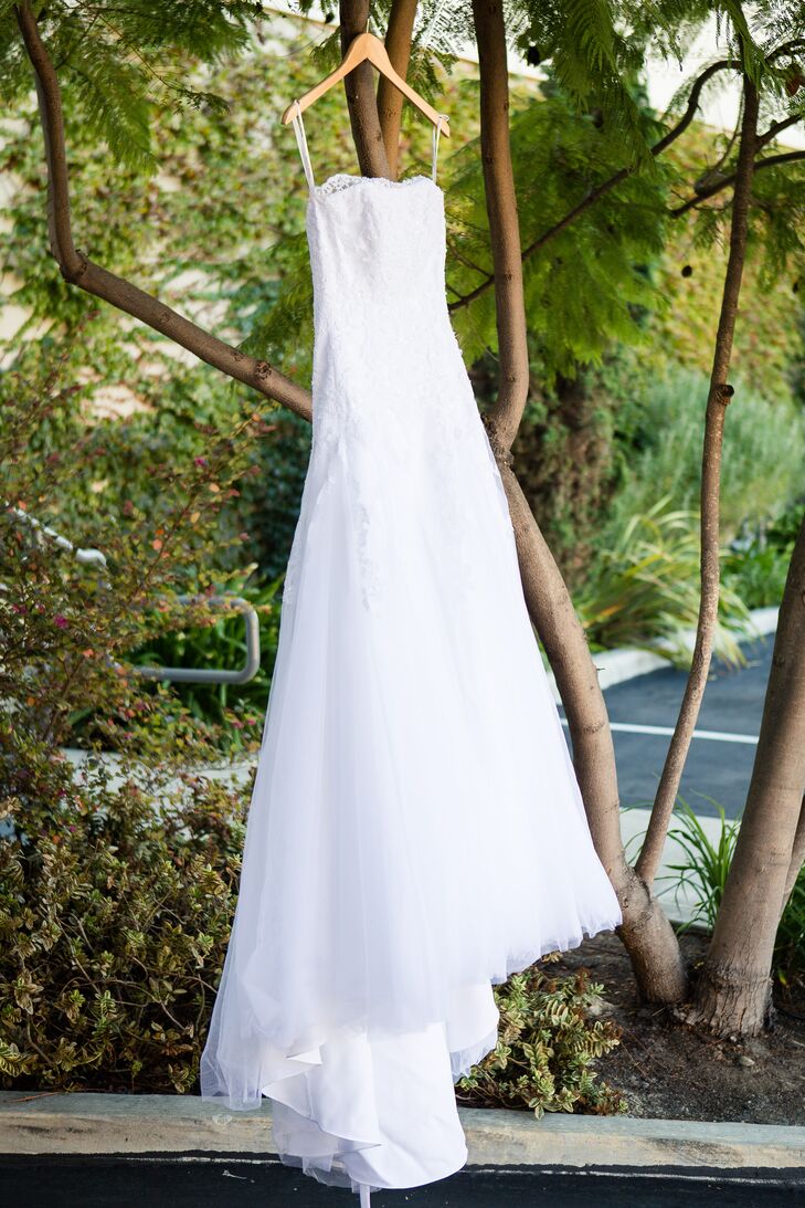 “Micaela's wedding dress was strapless with a fitted bodice and flared skirt. The bridesmaids wore long coral colored gowns with two straps,” says the couple. “The majority of the groomsmen wore service dress blue uniforms, and the groom's older brother wore a gray suit.”