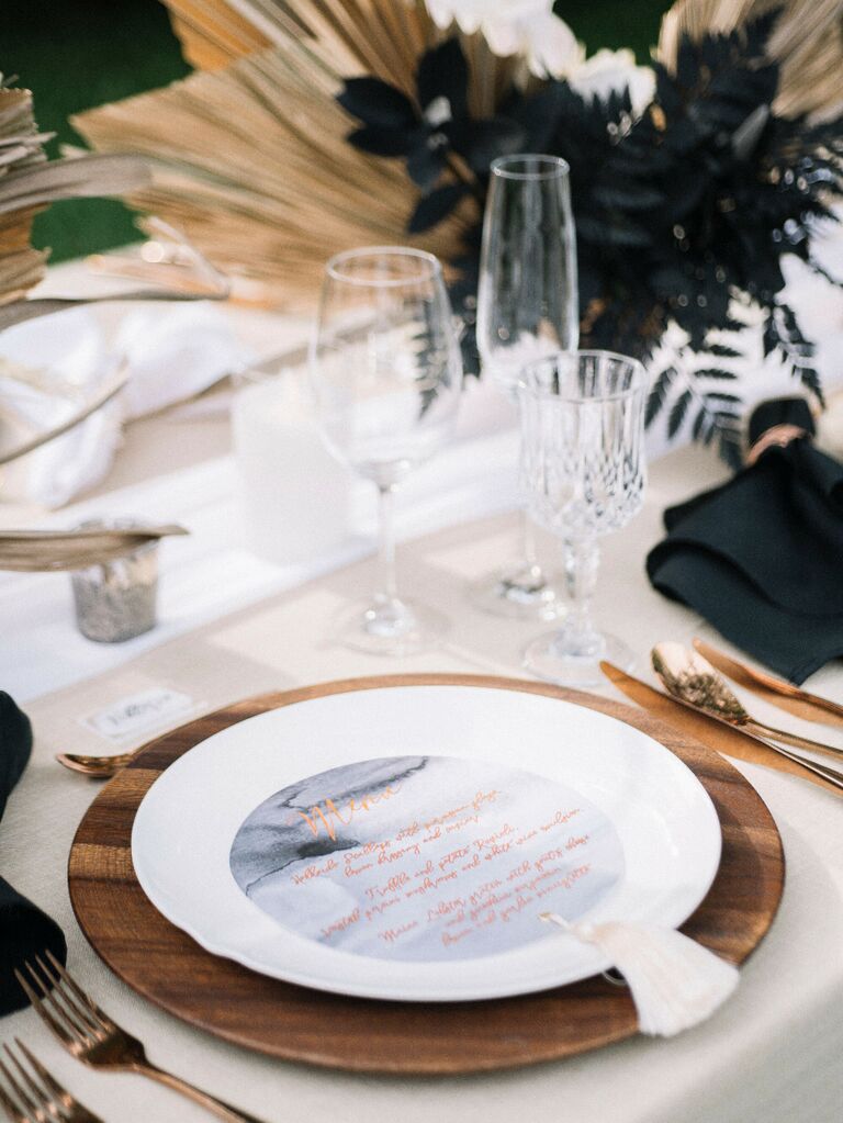 Wedding reception place setting with wood charger and marble menu