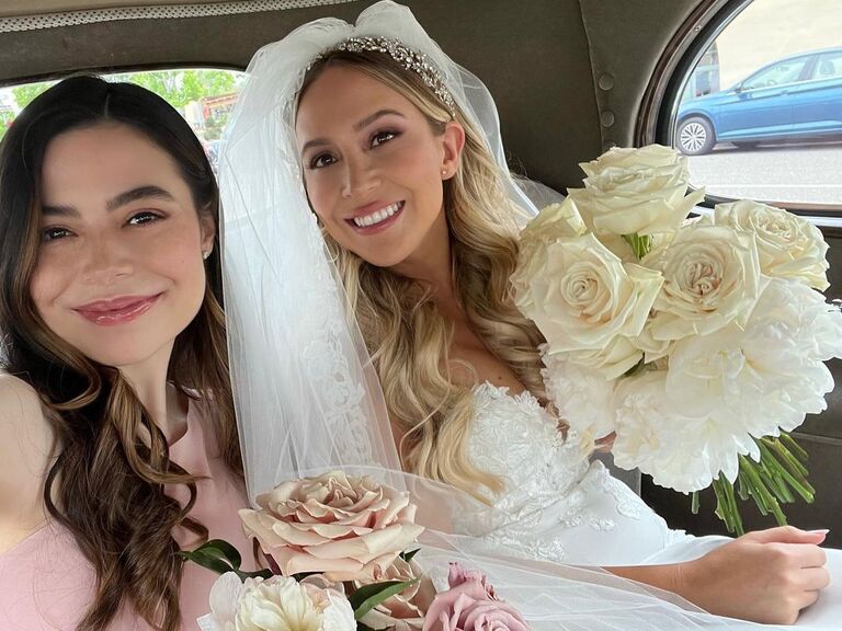 Miranda Cosgrove and the bride smile while taking a selfie. 