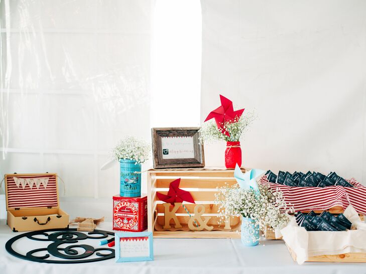 Escort cards were displayed in an adorable stripe-decorated wooden crate and surrounded by baby's breath floral arrangements and bold pinwheel accents.