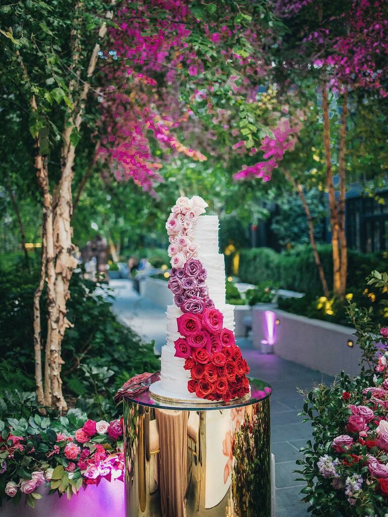 glamorous flower wedding cake with ombre cascading roses in light pink, purple, dark pink and red