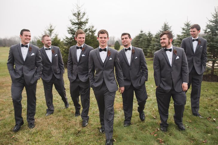 Mason and his groomsmen wore formal charcoal-gray tuxedos with mismatched black bow ties. They all wore pine cone and red berry boutonnieres in keeping with the wintry Christmas theme.