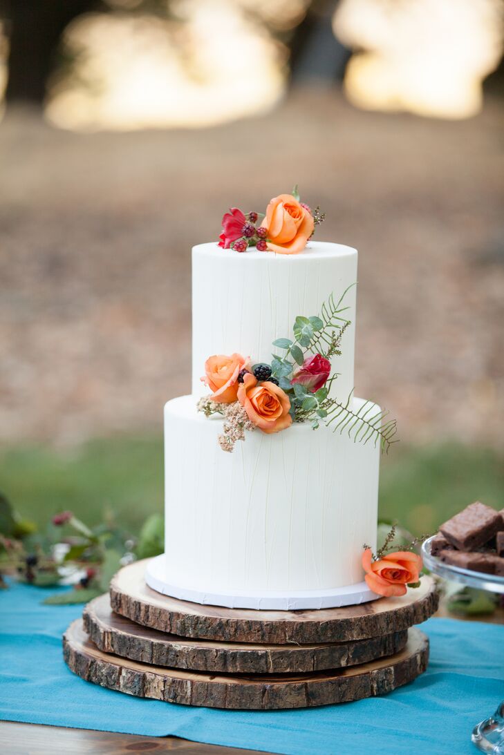 Karin and Ben's wedding cake from Crisp Bake Shop in Sonoma, California, was adorned with orange and red rose blossoms, echoing the day's vivid palette. "Practice cutting cakes together," Karin says. "Nobody tells you that cutting a cake, two people as one, is actually quite challenging. Seriously, practice."