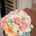 Lamb's ears and lisianthus lent texture to Emma's vintage-looking bouquet of garden roses, ranunculus and stock in shades of peach, coral and white.