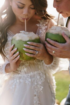 Bride and Groom With Wedding Rings Drinking Out of Fresh Coconuts