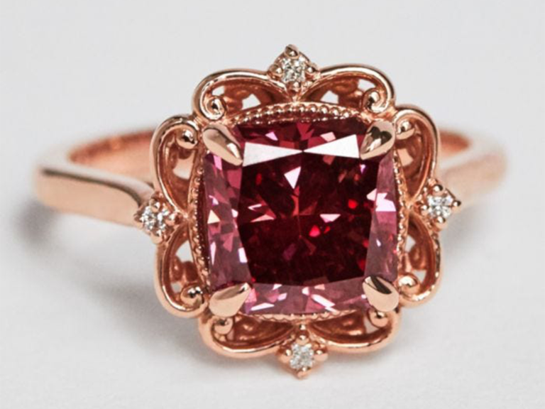 Cushion cut red diamond center with ornate rose gold halo