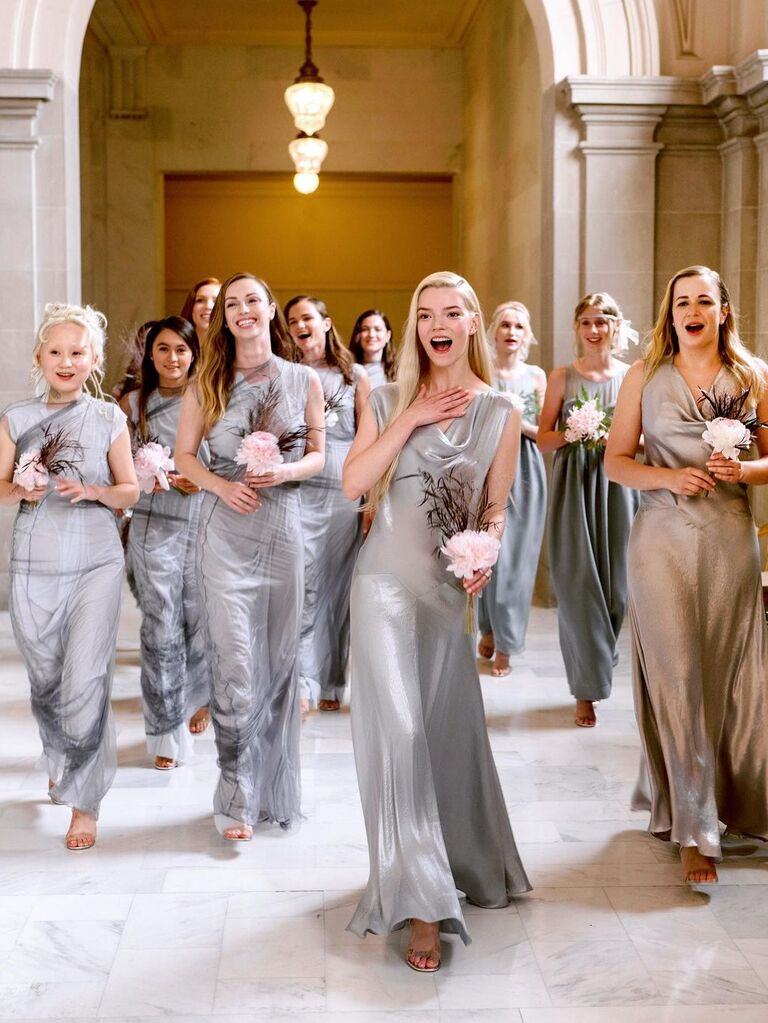 Anya Taylor Joy and other bridesmaids smile while walking down a hallway. 