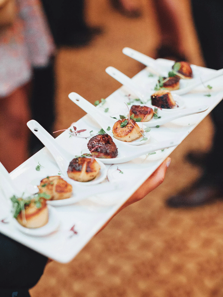 Scallops on spoons served as winter wedding food appetizers. 