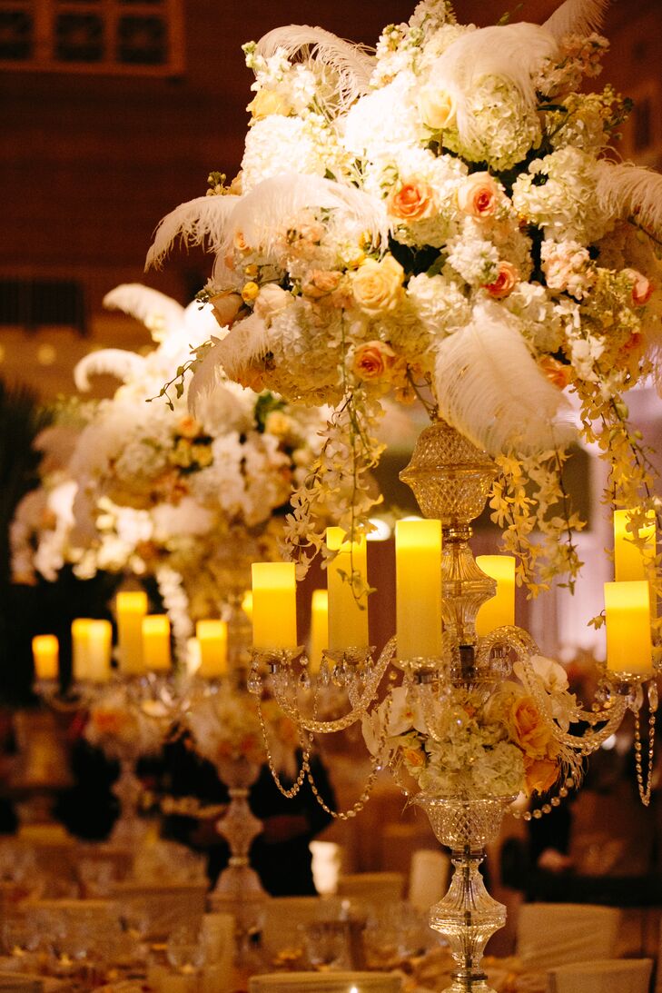 The reception’s standout feature was, without a doubt, Zak Events's glam centerpieces. The tall, cascading arrangements featured an abundance of fresh blooms in soft ivory, peach and pink hues, soft, oversize ostrich feathers and an ornate candelabra base that set alight each of the reception tables with its multitude of brightly lit ivory pillar candles.