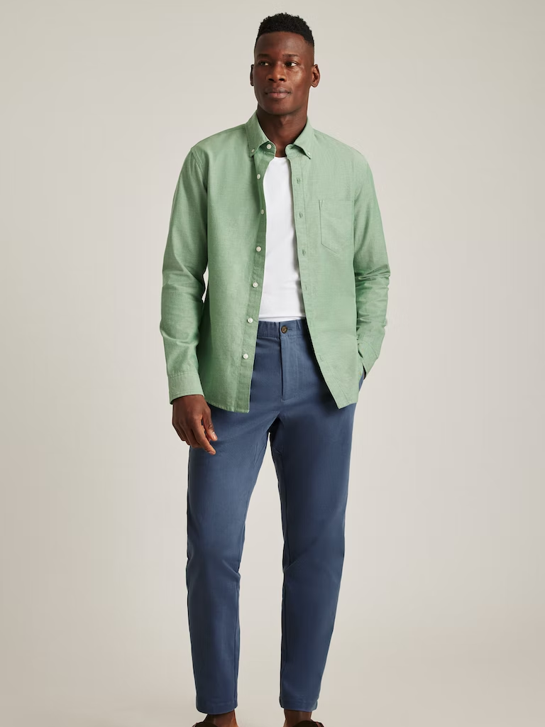 A model shows off this sage green button-up shirt.