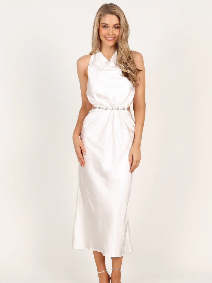A model shows off this white sheath dress with keyhole cutouts at the sides of the waist.