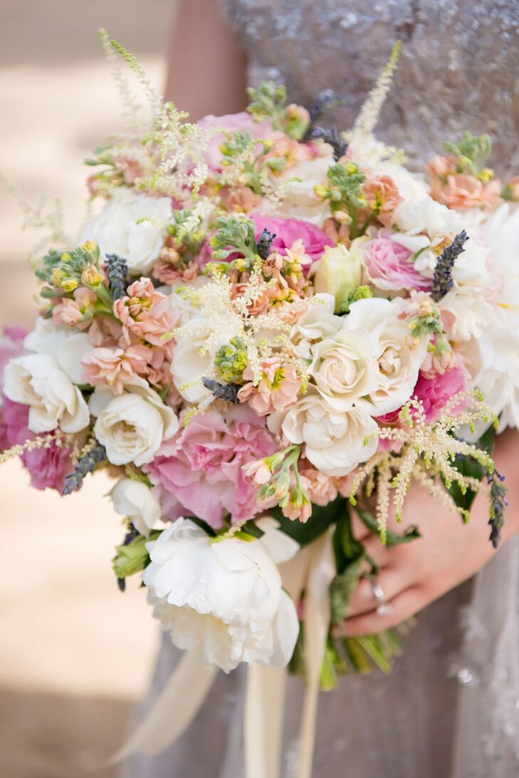 “I knew I wanted something light and airy feeling, something a little unstructured,” Anna says of her flowers. She showed her florist her wedding gown, discussed the color scheme and explained her concept of “whimsy and elegant romance.” The result? A bouquet of white peonies, peach stock, pink Lithuanians, cream roses, fresh lavender and eucalyptus, tied with trailing cream ribbons.