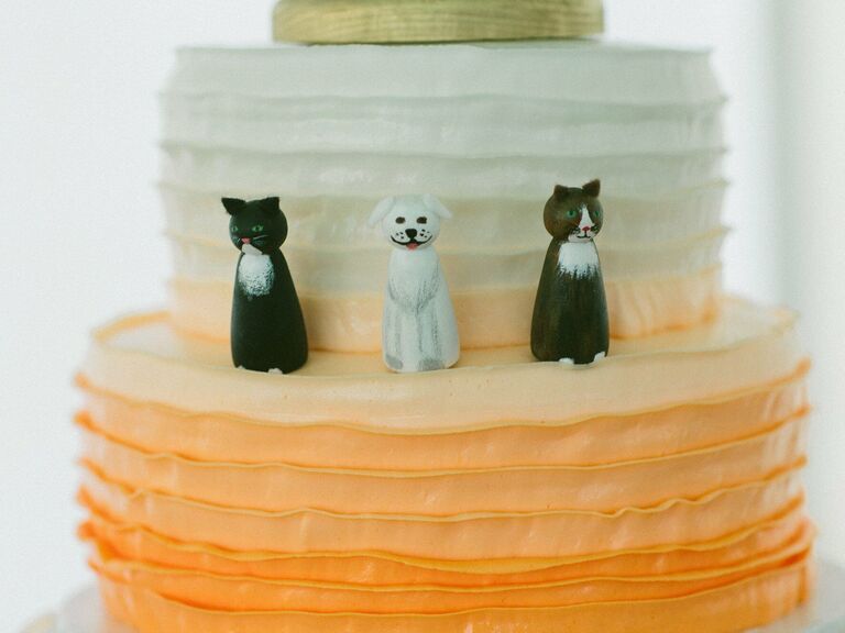 Animal wedding cake toppers of a couple's two cats and dog. 