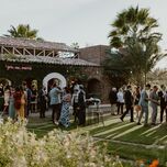 outdoor wedding cocktail hour with guests on lawn in front of stone building