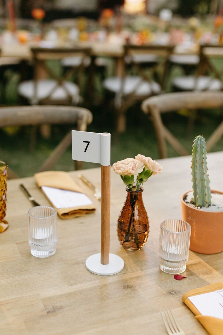 Minimalistic Flag Table Number on Dining Table With Bright Vases, Cacti, Carnations