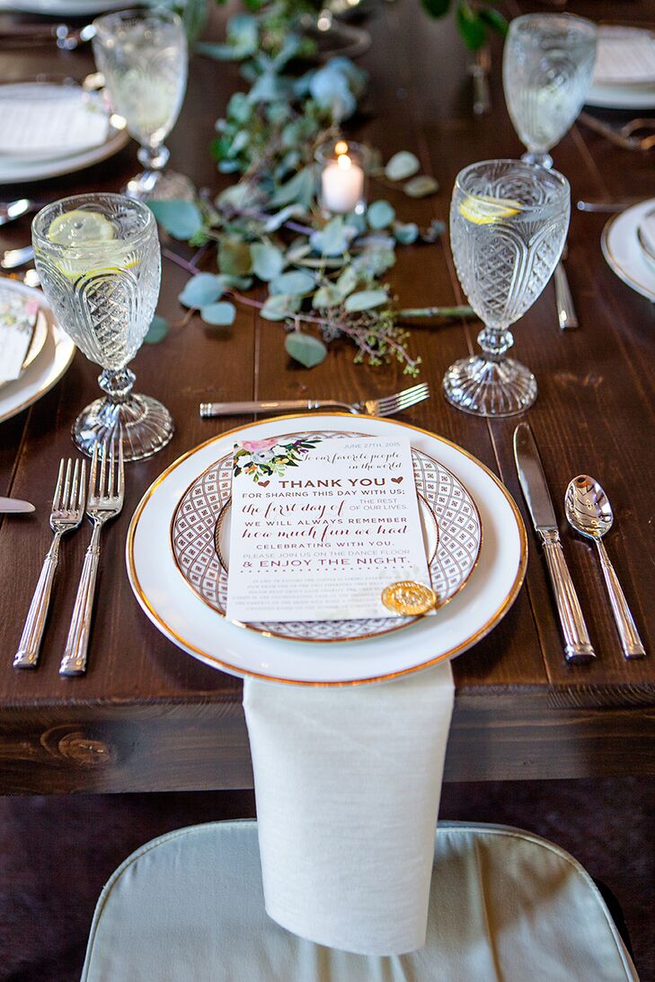 Wild-looking greenery was used as the table runners for the reception. Gold china and menus decorated with pops of gold completed the simple yet elegant look next to the crystal stemware.